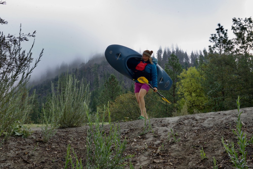 Genzoli carries her kayak to the river.