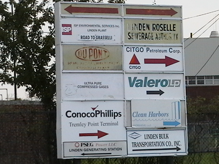 A billboard with signs for chemical and fuel companies in the area