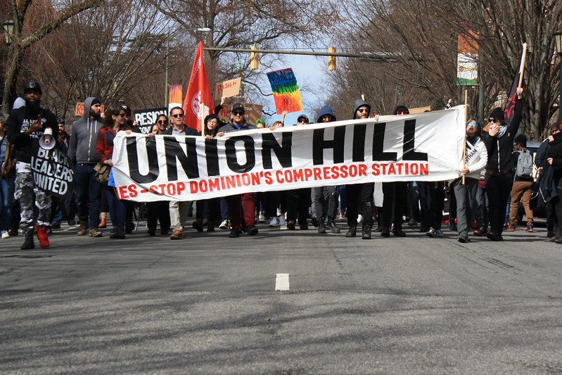 People carrying union hill banner walk down the street