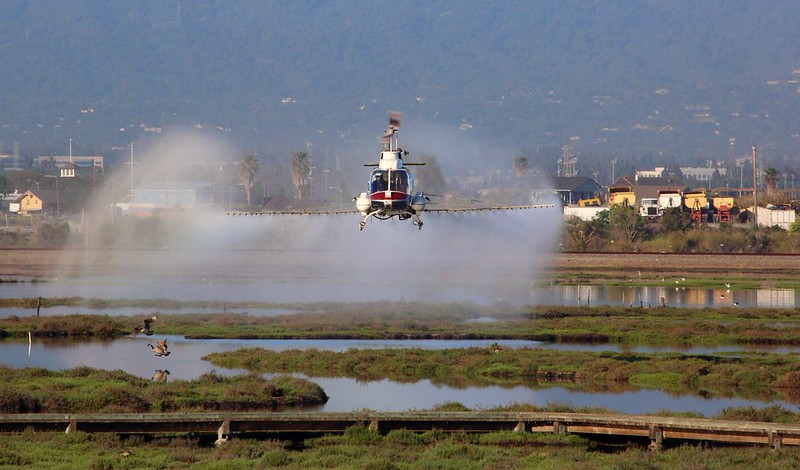 plane sprays pesticides over wetland