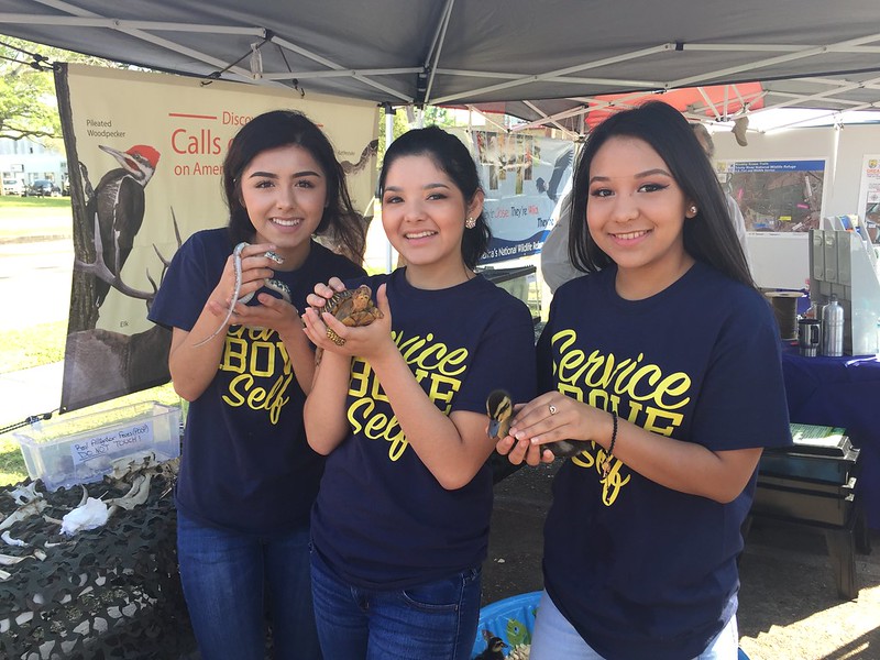 Three students hold small animals