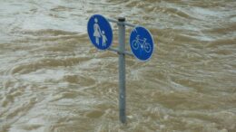 bike and pedestrian crossing sign in floodwaters