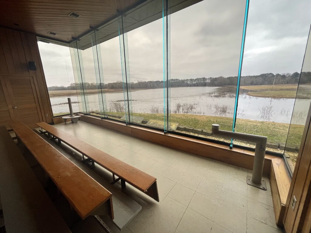 Room with windows overlooking water and marsh. 