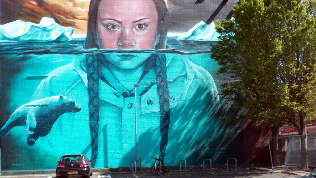A mural depicts climate activist Greta Thunberg underwater near a melting glacier.