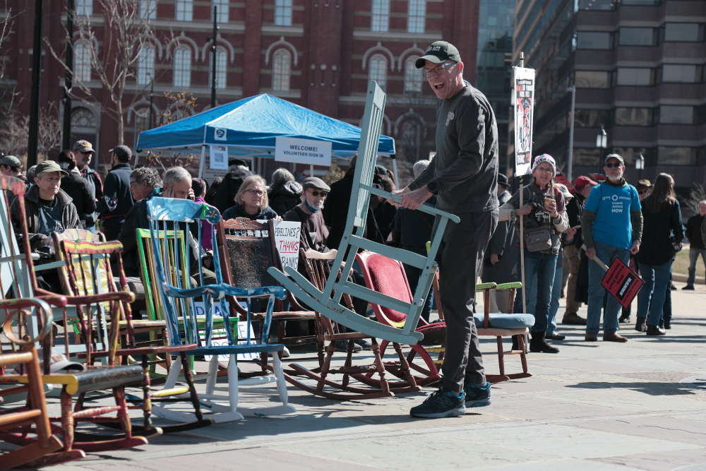 A line of colorful rocking chairs at a climate protest