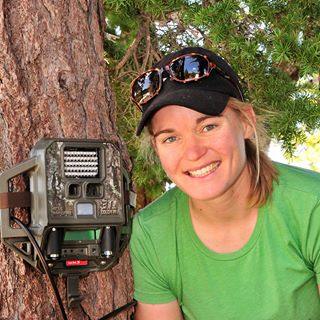 Woman next to monitoring device on tree.