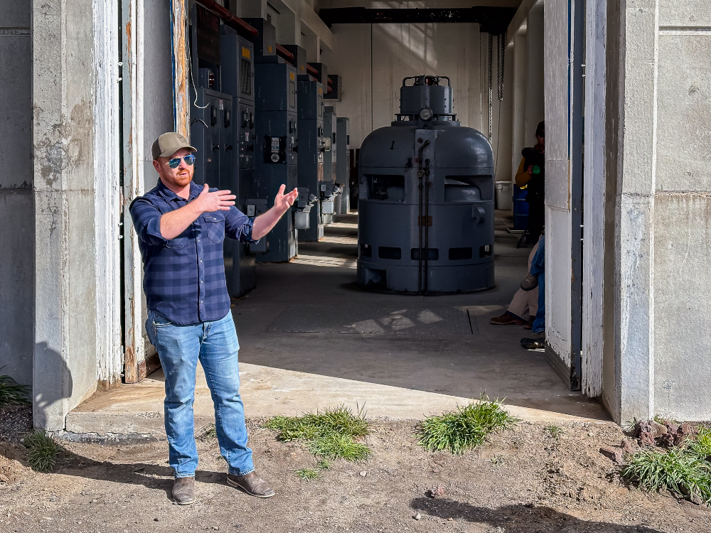 A man stands in front of large industrial equipment