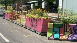 A parklet in Washington DC with brightly colored planters filled with local pollinator plants.