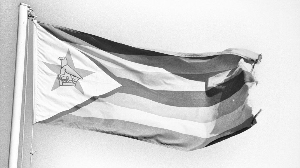 A tattered Zimbabe flag in black and white