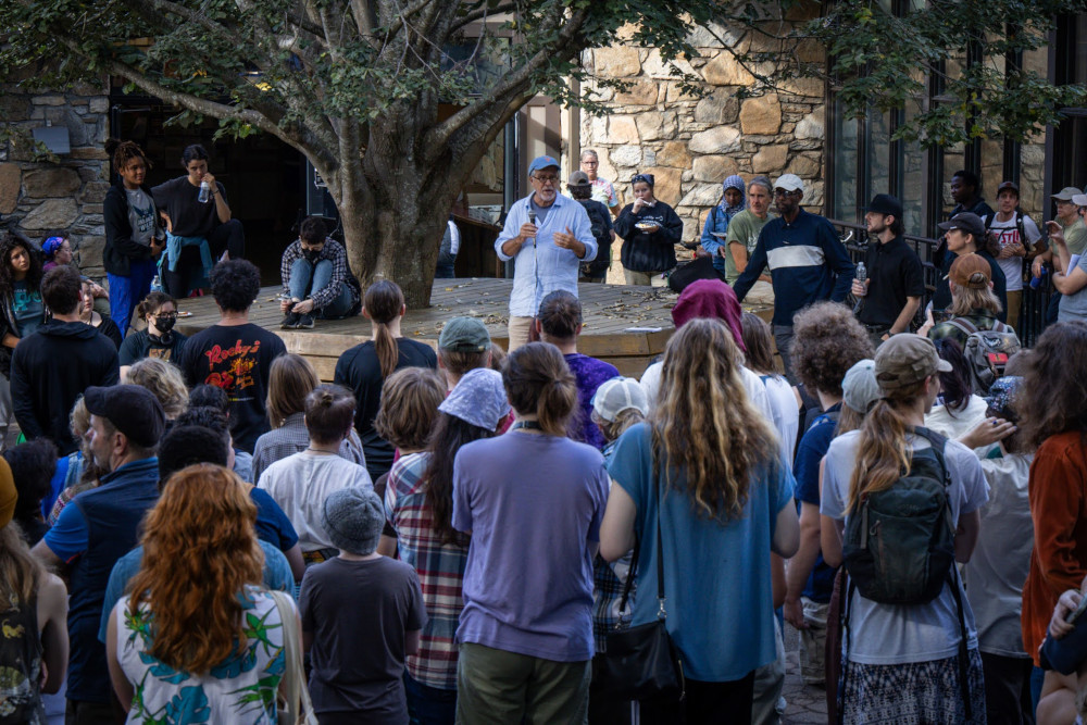 Students and faculty gather around to hear the college president speak