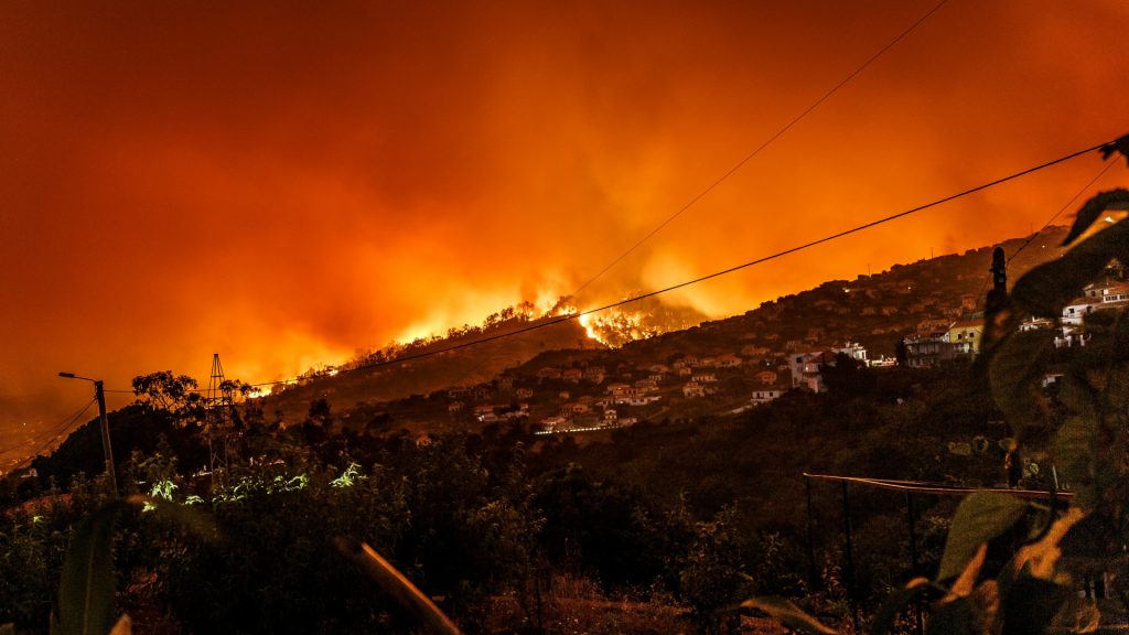 Wildfires over the crest of a hill