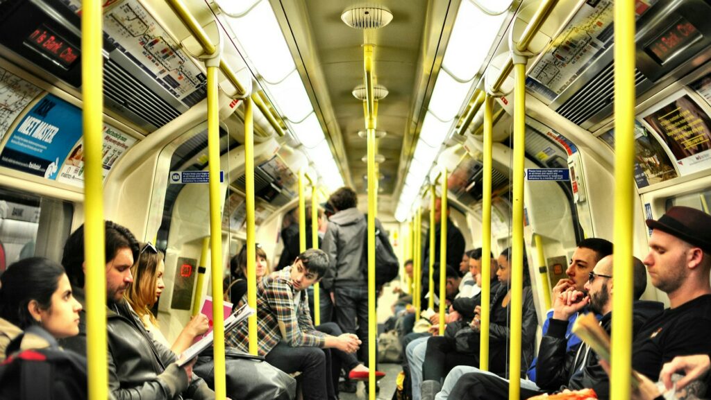 Crowded subway train with people sitting and standing.