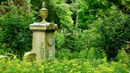 A grave marker sits in a field of green